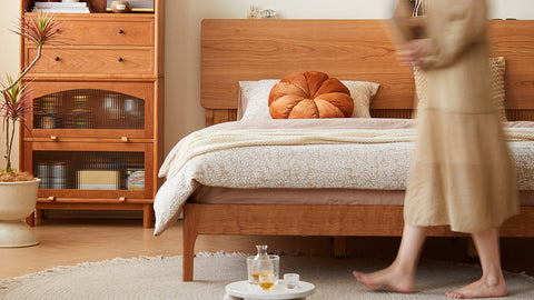 Cozy wooden bed frame with soft bedding and a warm-toned pillow, styled with a modern cabinet and minimalistic decor, showcasing LoftHome's beds collection.