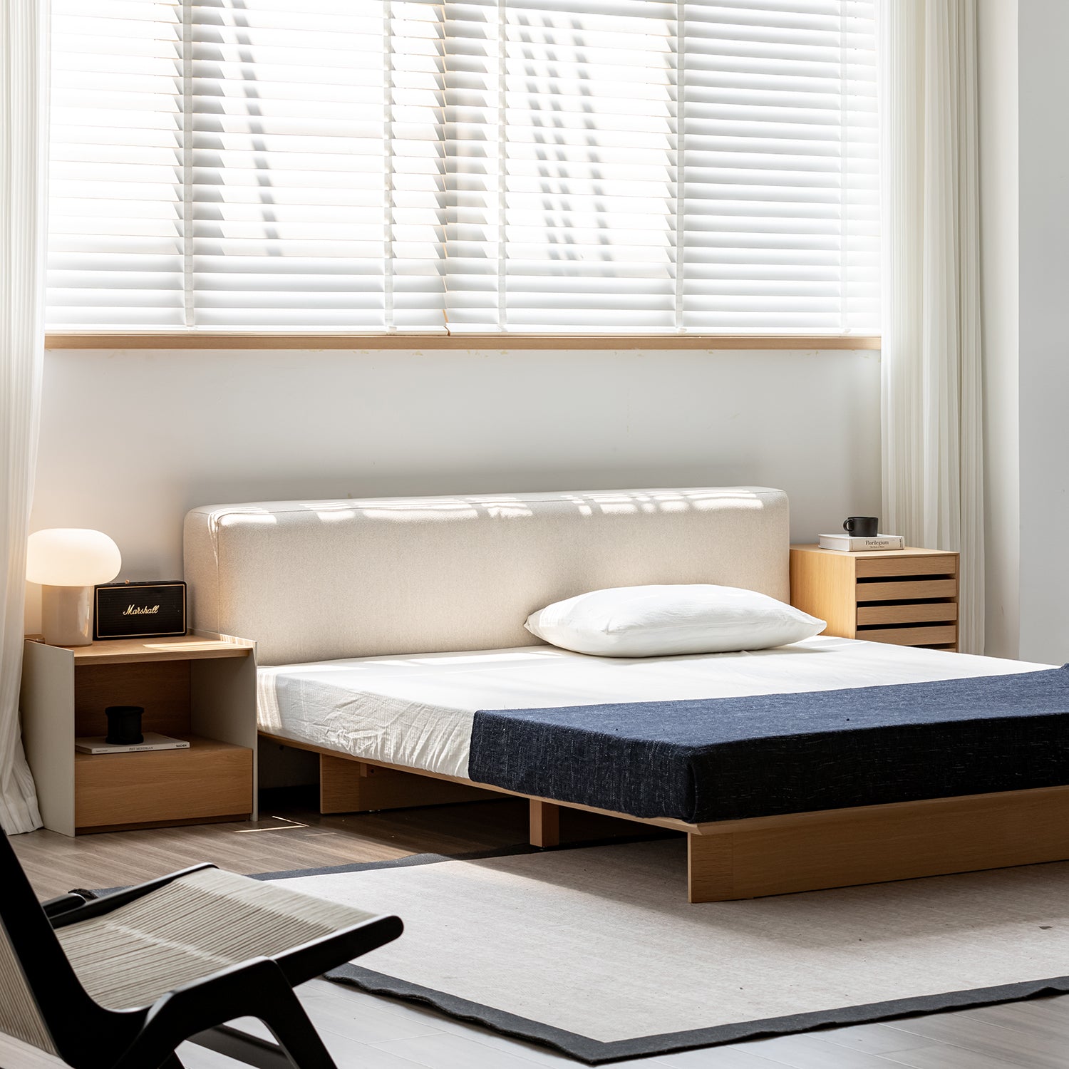 Modern bedroom with a bed, nightstands, and a chair.